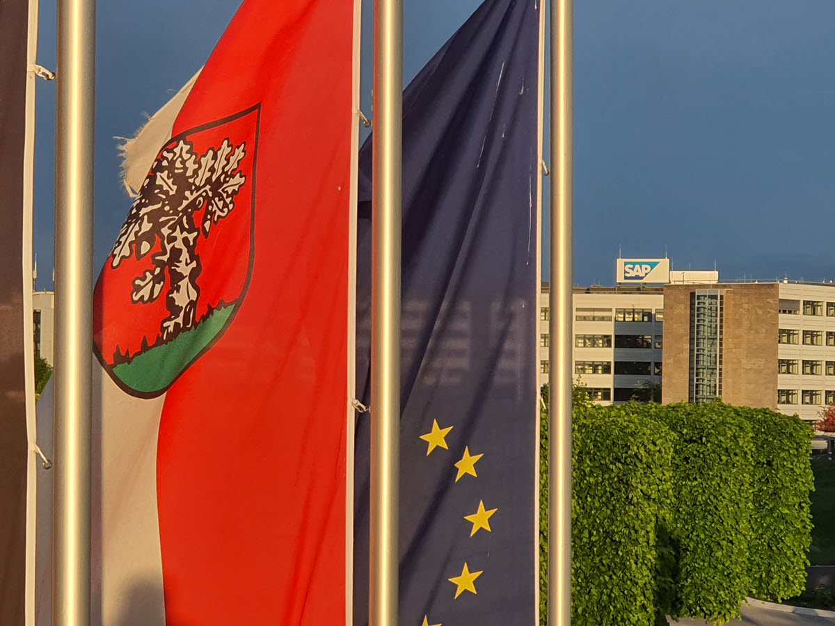 Wehende Walldorfer und Europa-Flagge - Im Hintergrund: Ein SAP Gebäude