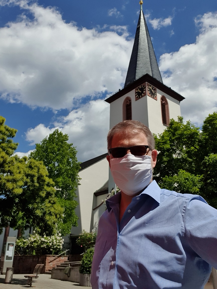 Dr. Clemens Kriesel mit Mund-Nasen Bedeckung vor der kath. Kirche